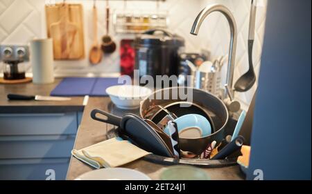 una montagna di piatti non lavati. Lavoro a casa Foto Stock