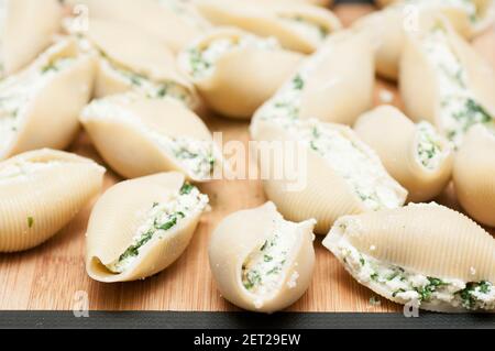 pasta conchiglie farcita a mano senza cottura con formaggio di capra e spinaci e una salsa marina Foto Stock