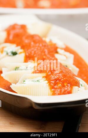 pasta conchiglie farcita a mano senza cottura con formaggio di capra e spinaci e una salsa marina Foto Stock