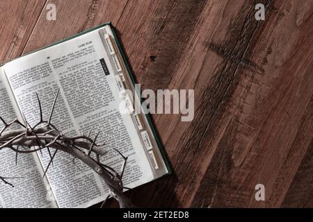 corona di spine sulla bibbia aperta su legno scuro con spazio di copia Foto Stock