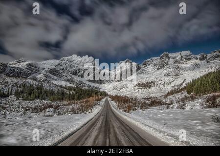 Strada dritta verso le montagne, Lofoten, Nordland, Norvegia Foto Stock