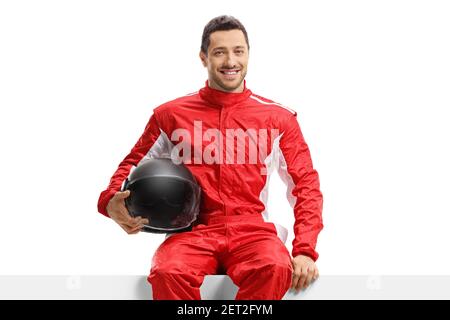 Auto da corsa in uniforme rossa seduta su un pannello tenendo un casco isolato su sfondo bianco Foto Stock