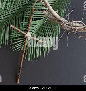 corona di spine e fronde di palme con croce di legno sfondo nero con spazio per la copia Foto Stock