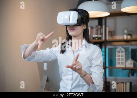 Donna che indossa occhiali VR a casa. Foto Stock