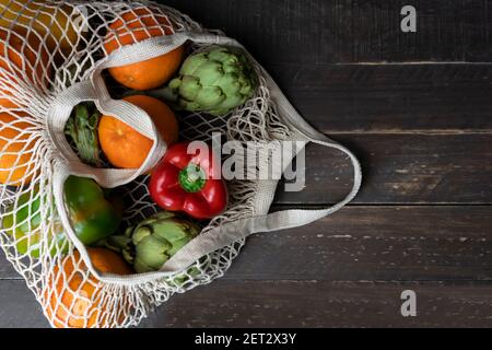 Vista dall'alto di verdure biologiche fresche e frutta in borsa eco-friendly riutilizzabile su sfondo rustico di legno.concetto di zero rifiuti, senza plastica. Foto Stock