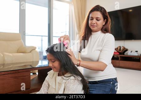 Donna che combatte i capelli della figlia Foto Stock