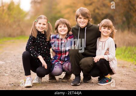 Quattro ragazze adolescenti felici che camminano nel parco autunnale . Foto di alta qualità Foto Stock