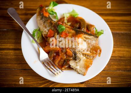 nasello intero stufato con carote, barbabietole, peperoni e altre verdure. Foto Stock