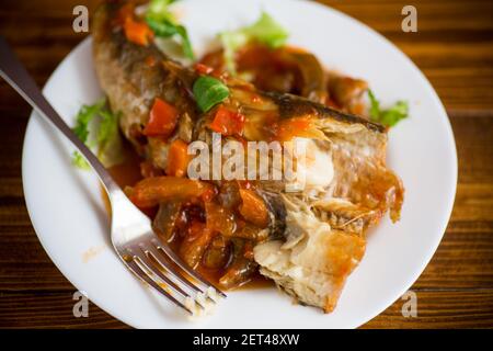 nasello intero stufato con carote, barbabietole, peperoni e altre verdure. Foto Stock