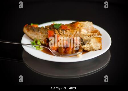 nasello intero stufato con carote, barbabietole, peperoni e altre verdure. Foto Stock