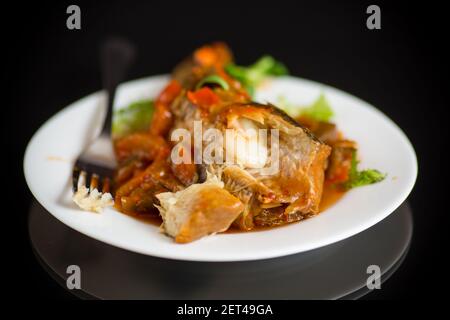 nasello intero stufato con carote, barbabietole, peperoni e altre verdure. Foto Stock