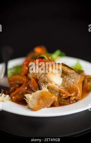 nasello intero stufato con carote, barbabietole, peperoni e altre verdure. Foto Stock