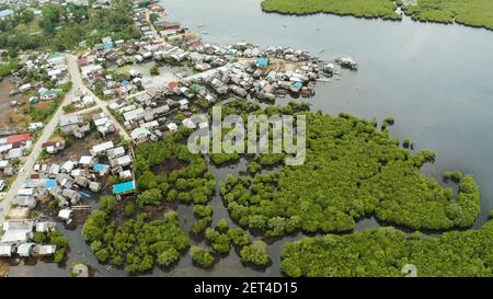 Città in zone umide e mangrovie sulla costa dell'oceano dal di sopra. Siargao island, Filippine. Foto Stock