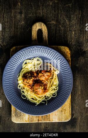 Vista dall'alto di una ciotola di spaghetti con polpette all'interno salsa di pomodoro Foto Stock