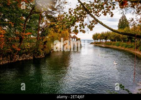 Canale da Bodensee e argine con vicolo alberato con foglie splendidamente colorate nel parco pubblico in bella giornata di sole autunno. Konstanz, Germania. Foto Stock