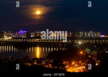 Vista serale di Kiev, Ucraina, una vista del ponte di Paton e la riva sinistra sotto il faro. Foto Stock