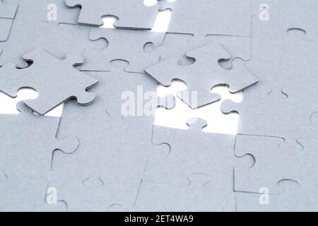 Pezzi di puzzle incompleti su sfondo bianco. Foto Stock