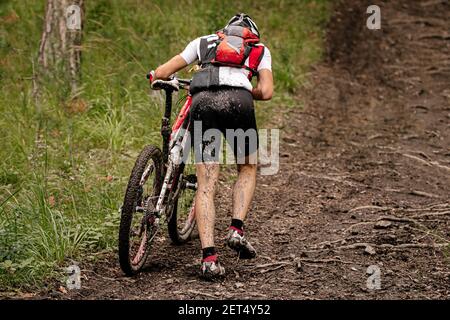 ciclista con mountain bike salita su sentiero forestale Foto Stock