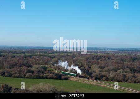 una locomotiva a vapore vintage tira un breve treno attraverso scenic Paesaggio sulla ferrovia Swanage Heritage nel Regno Unito Foto Stock