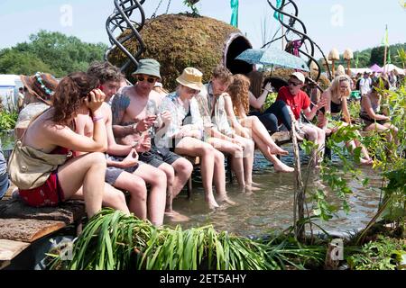 I festaioli si rinfrescano nel Green Field stagno il giorno 4 di Glastonbury 2019, Worthy Farm, Pilton, Somerset. Data immagine: Sabato 29 giugno 2019. Il credito fotografico dovrebbe essere: David Jensen Foto Stock