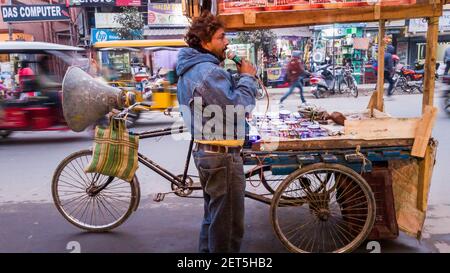 Malda, Bengala Occidentale, India - Gennaio 2018: Un venditore indiano di strada con il suo carrello gommato che annuncia i suoi articoli su un mike. Foto Stock