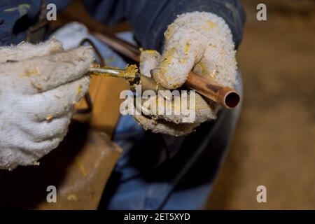 Applicazione del flussante sul raccordo in ottone per acqua di saldatura del giunto di rame sistema di tubi Foto Stock