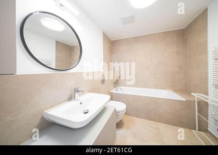 un piccolo bagno con lavandino, wc e piante in cestini sulla parete accanto  al lavandino c'è uno specchio Foto stock - Alamy