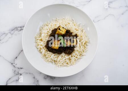 Palak Paneer o Saag Paneer con riso basmati al vapore sfondo bianco Foto Stock