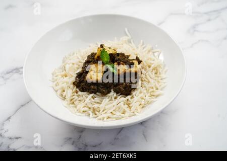 Palak Paneer o Saag Paneer con riso basmati al vapore sfondo bianco Foto Stock