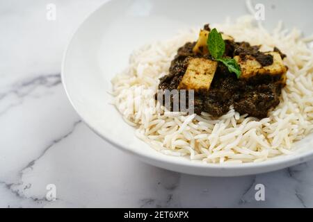 Palak Paneer o Saag Paneer con riso basmati al vapore sfondo bianco Foto Stock