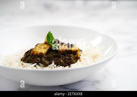 Palak Paneer o Saag Paneer con riso basmati al vapore sfondo bianco Foto Stock