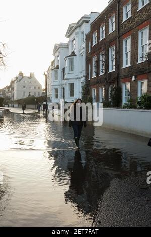 Londra, Regno Unito. 01 Marzo 2021. High Tide copre Upper Mall, Hammersmith. Le maree eccezionalmente alte sul Tamigi oggi hanno coperto la strada a Upper Mall, Hammersmith. Adulti, bambini, piccoli cani e ciclisti si divertono in acqua. Credit: Peter Hogan/Alamy Live News Foto Stock