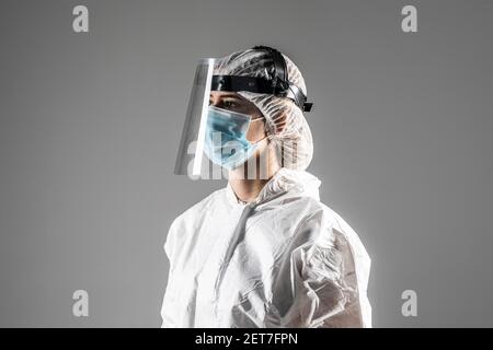 Closeup foto di donna esperto doc virologia centro clinica usura maschera respiratoria hazmat blu uniforme tuta protettiva facciale in plastica grigio isolato Foto Stock