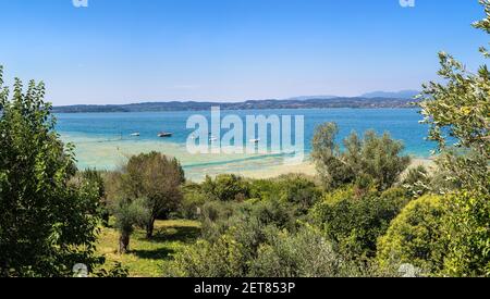 Panorama del lago di Garda, spiaggia pubblica a Sirmione in una bella giornata estiva, Italia Foto Stock