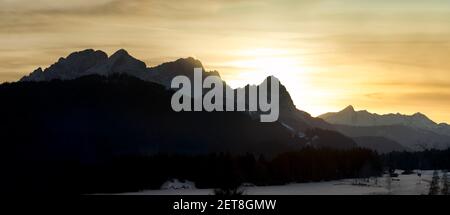 Tramonto in montagna - panorama di Zugspitze e Alpspitze durante l'epico tramonto sulla polvere del sahara Foto Stock