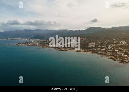 Vista aerea dal drone di idilliaco mare con montagne innevate. Foto Stock