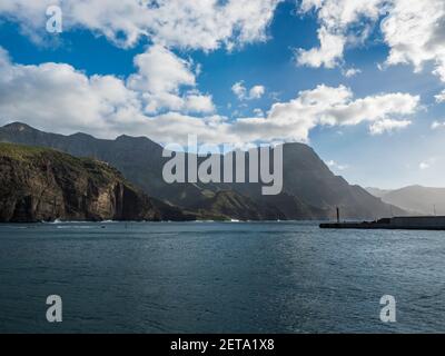 Vista sulle montagne verdi di Tamadaba, sull'oceano e sul faro dal porto di Puerto de las Nieves, villaggio di pescatori tradizionale. Agaete, Gran Canaria, Canarie Foto Stock