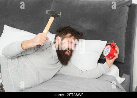 Anche se si sono addormentati potreste svegliarvi con la sensazione che non ha sonno a tutti. Fasi di sonno. Cattura fino a perdere il sonno durante il fine settimana. Risveglio mattutino. L'uomo sveglio infelice con sveglia squilla. Foto Stock