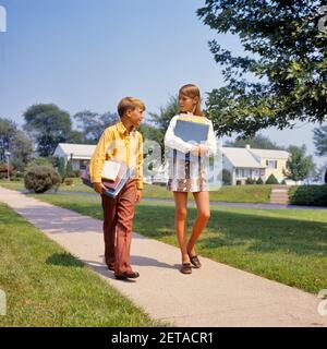 1960 RAGAZZA ANNI 1970 SUL MARCIAPIEDE A PIEDI CASA DA O. A SCUOLA CHE PARLA PORTANDO I LIBRI RAGAZZA CHE INDOSSA MINI FAUX DI PELLE DI SERPENTE GONNA - KS7526 HAR001 HARS 1 COMUNICAZIONE GIOVANILE DI STILE ELEMENTARE AMICO MINI GIOIA LIFESTYLE DONNE CASE FRATELLI SALUTE VITA DOMESTICA COPIA SPAZIO AMICIZIA FULL-LENGTH RESIDENZIALE MASCHI EDIFICI FRATELLI SORELLE SCUOLE GRADO FELICITÀ CASE DI QUARTIERE PRIMO FRATELLO COLLEGAMENTO FAUX FRIENDLY RESIDENCE MINISKIRT DELLA SCUOLA MEDIA, GIOVANI ALLA CRESCITA SCOLASTICA DI CLASSE O COOPERATION PRE-TEEN PRE-TEEN RAGAZZA TOGETHERNESS CAUCASICO ETNIA HAR001 VECCHIO STILE Foto Stock