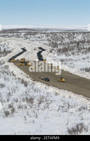 Stendere il tessuto geotessile (protegge il permafrost) e stendere ghiaia sulla Inuvik-Tuktoyaktuk Highway, territori del Nord-Ovest, Artico del Canada. Foto Stock