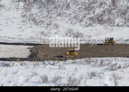 Stendere il tessuto geotessile (protegge il permafrost) e stendere ghiaia sulla Inuvik-Tuktoyaktuk Highway, territori del Nord-Ovest, Artico del Canada. Foto Stock