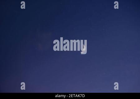 Paesaggio notturno sfocato, cielo stellato blu scuro, vista della luna luminosa (Crescent) in tempo senza nuvole. Foto Stock