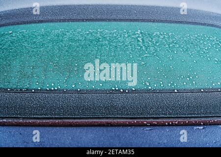 Finestrino posteriore della vettura bloccato in primo piano. Trasporti e sfide della stagione invernale. Foto Stock