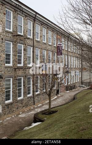 Grandi edifici rinnovati lungo il fiume Lamprey nel centro di Newmarket, NH. Appartamenti, studio di yoga, ristorante, gelateria, una produzione di biciclette Foto Stock