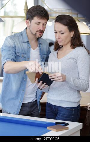 uomo e donna che guardano campioni di colore di legno Foto Stock