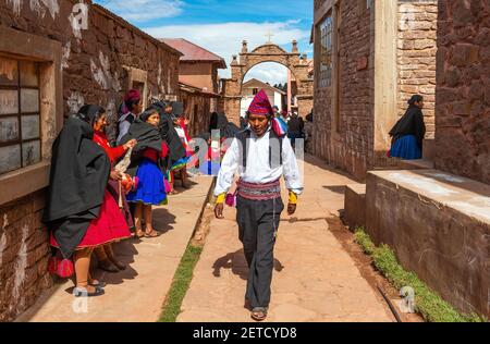 Indigeni peruviani Quechua gente in abiti tradizionali in una strada di Taquile isola, lago Titicaca, Perù. Foto Stock