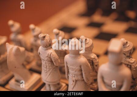 Una scacchiera decorativa con antichi pezzi di scacchi guerrieri asiatici Foto Stock