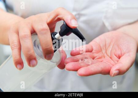 Primo piano lavando la mano con l'igienizzante imbevuto di alcol Foto Stock