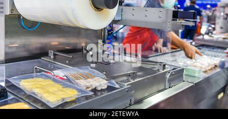 Linea automatica per la produzione di alimenti su macchine a nastro trasportatore in fabbrica, produzione alimentare industriale Foto Stock