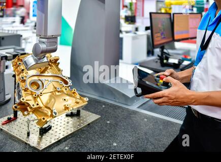 Ingegnere meccanico che utilizza le tecnologie di misurazione 3d CMM (coordinate Measuring Machine) per verificare la validità del blocco motore per il settore industriale Foto Stock